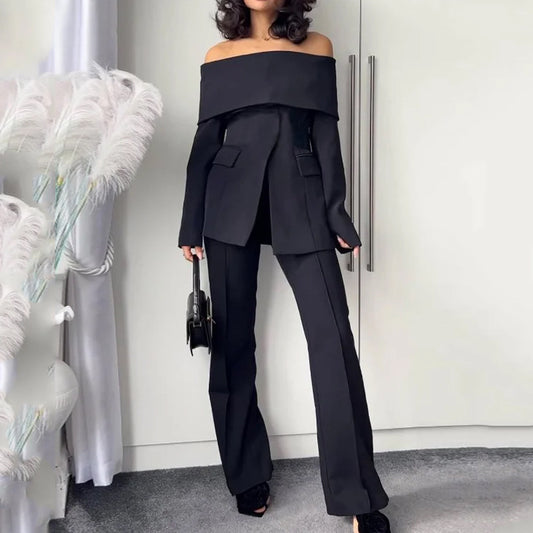 A woman wearing a black off-the-shoulder suit and heels.