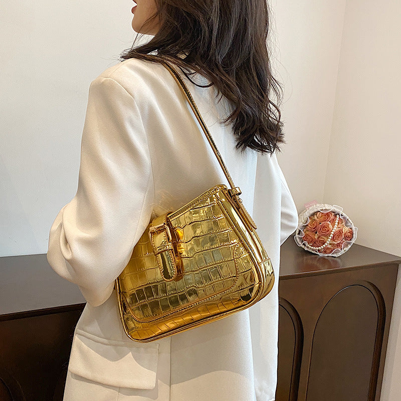 A gold crocodile print bag.