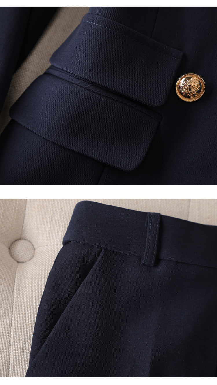 Navy suit jacket pocket and gold button, complemented by navy pants with pockets.