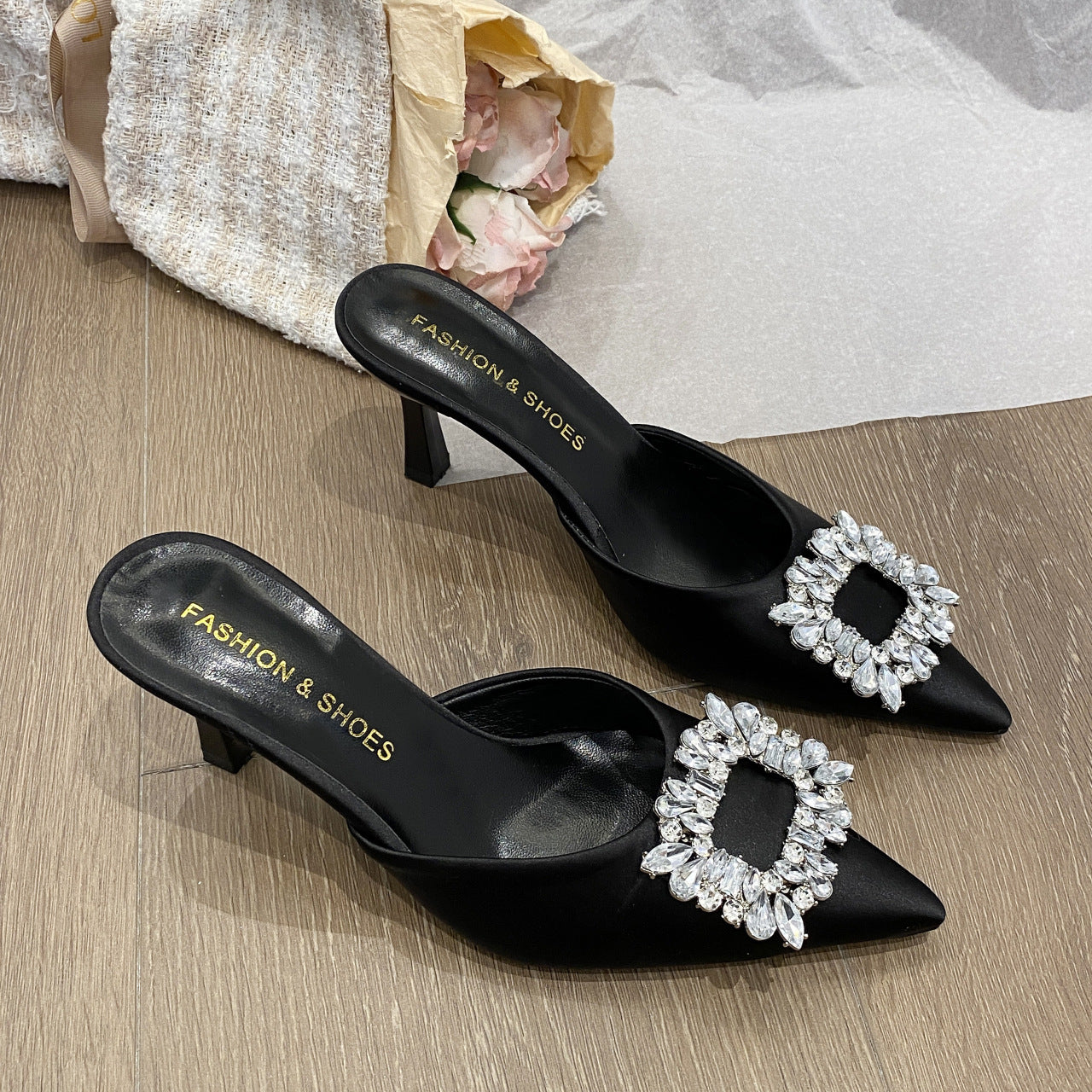 "Sophisticated black heels with crystal embellishments, featuring a pointed heel and square rhinestones for added elegance."