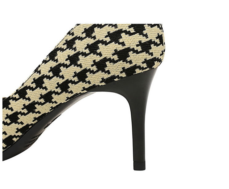 Close up back side view of Women's black and cream patterned fabric material high heels with elegant pearls and intricate gold detailing. Black stiletto.