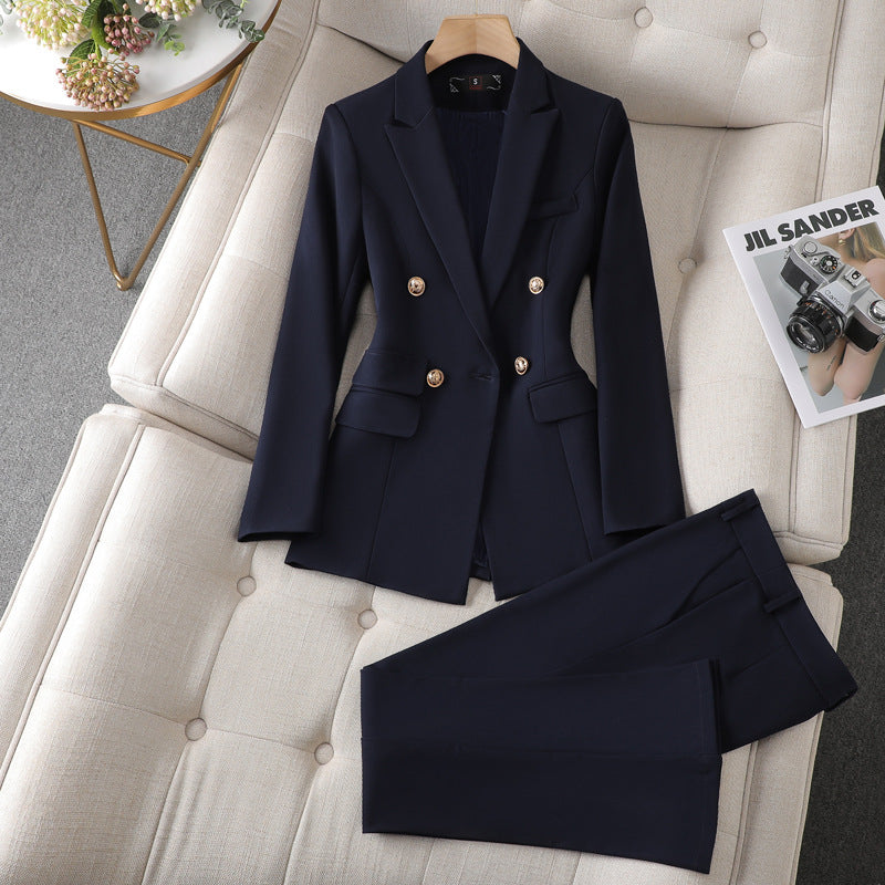 A navy suit and pants neatly placed on a couch, creating a sophisticated and elegant look.