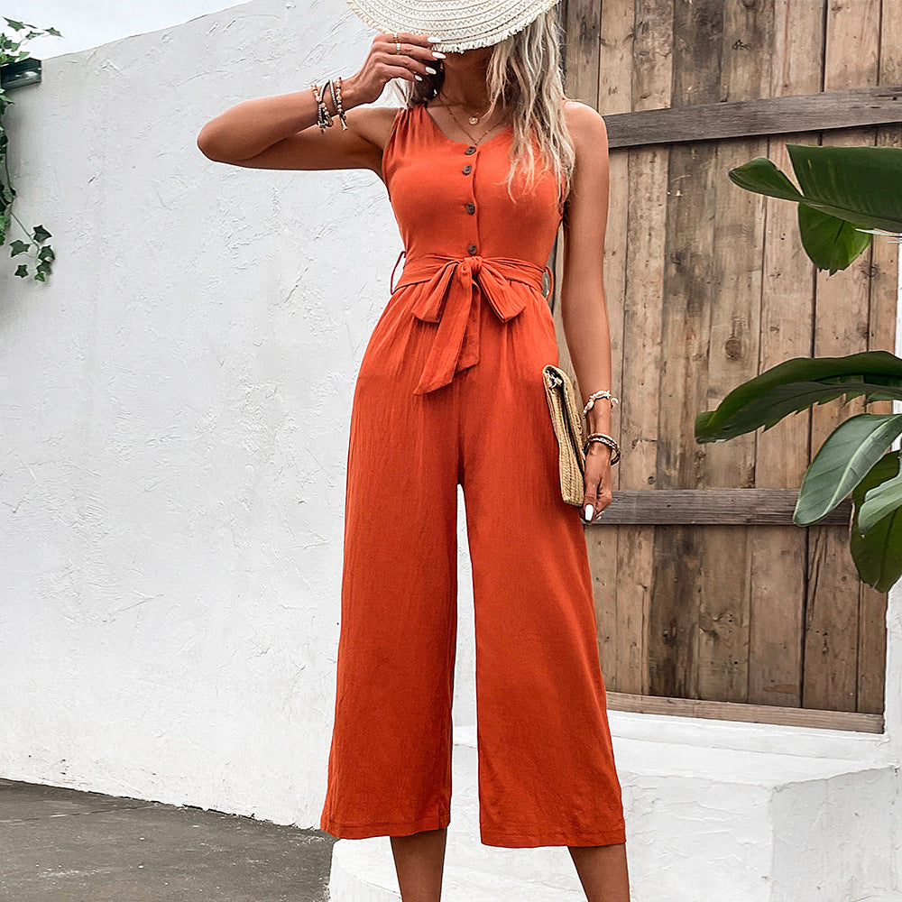 Fashionable women's orange summer jumpsuit with wide leg pants, sleeveless v-neck, and buttoned closure.