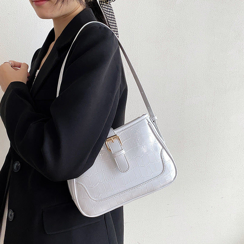 A white crocodile print bag.