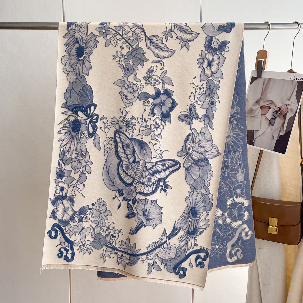 A blue floral print cashmere scarf with butterflies stands gracefully beside a car, exuding elegance and style.