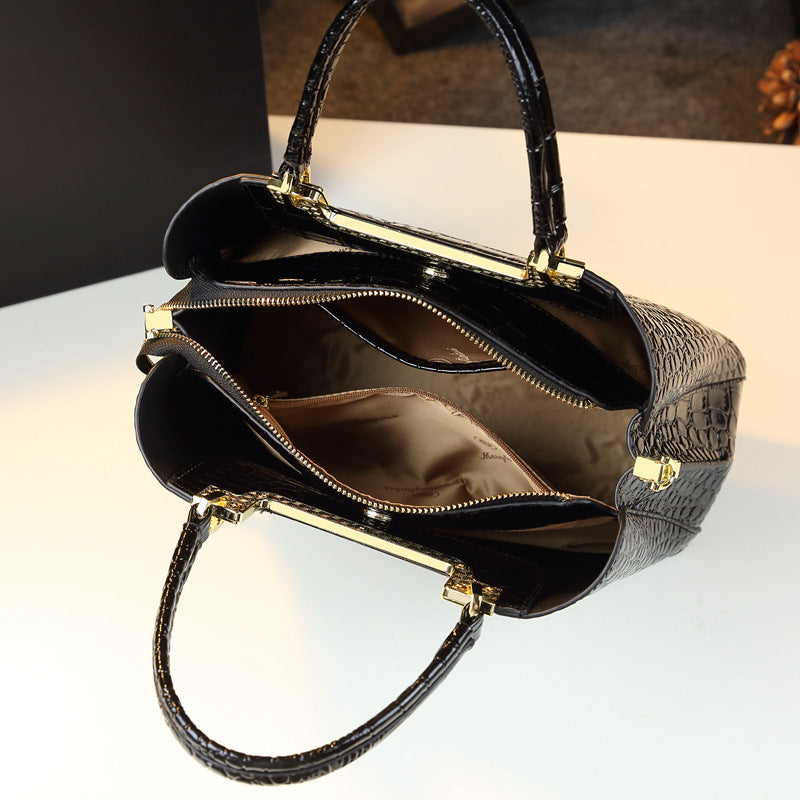 A black and gold handbag with gold hardware, featuring an interior of black Menglinkai snakeskin-like material.