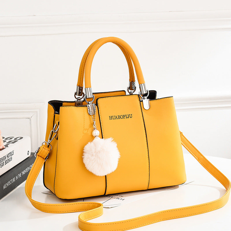  Stylish yellow handbag by Huabopiju adorned with a cute pom pom on the strap, complete with a zipper pocket."