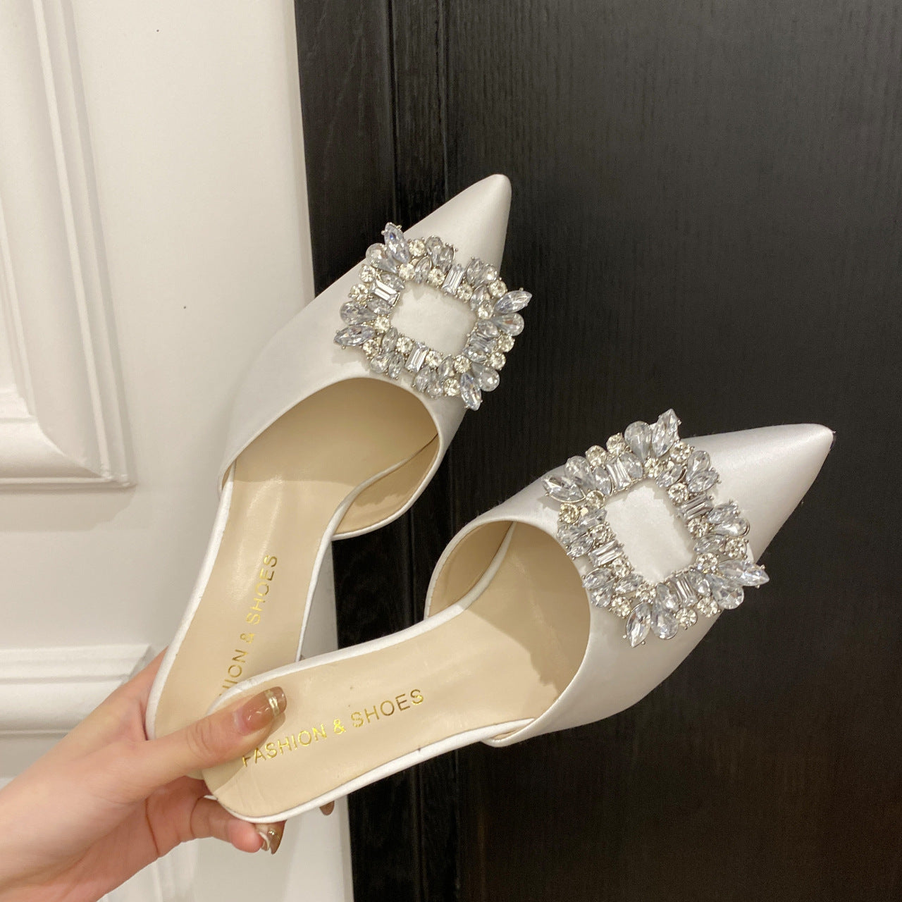 "Sophisticated white heels with crystal embellishments, featuring a pointed heel and square rhinestones for added elegance."