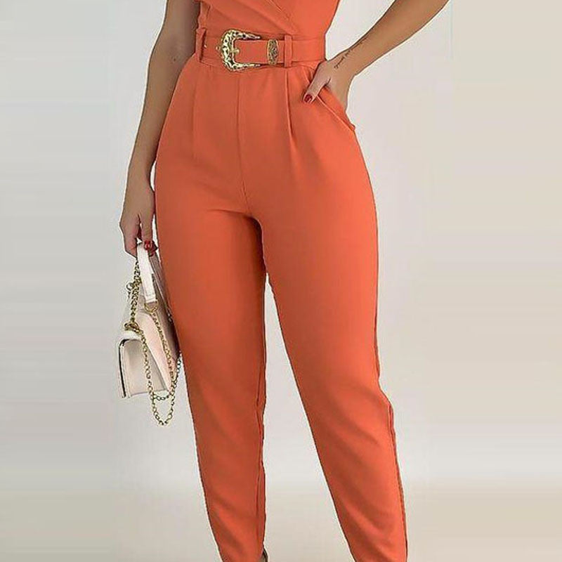 An elegant lady in an orange jumpsuit, accentuated by a stylish belt, radiating sophistication and grace.