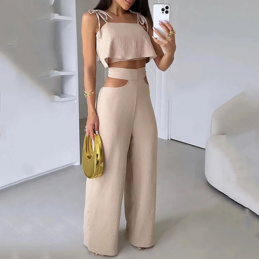 "Image of a woman in a tan jumpsuit capturing a selfie, donning a beige cream top with exposed pants."