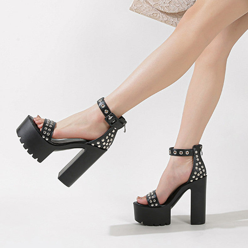  "Black Rivet studded high heels with ankle straps, and platform design on a woman's legs."