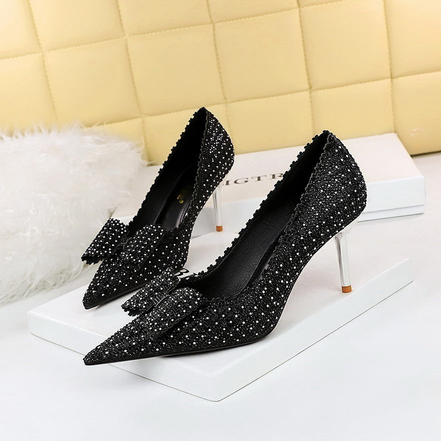 Black Rhinestone Heel adorned with a graceful bow, adding a touch of elegance and sparkle to your ensemble."